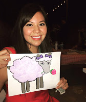 Amber McCrary headshot holding a drawing of a sheep