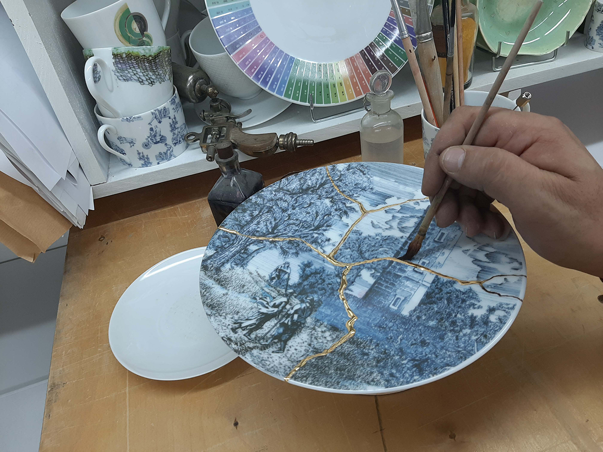 Artiste décore une assiette en porcelaine