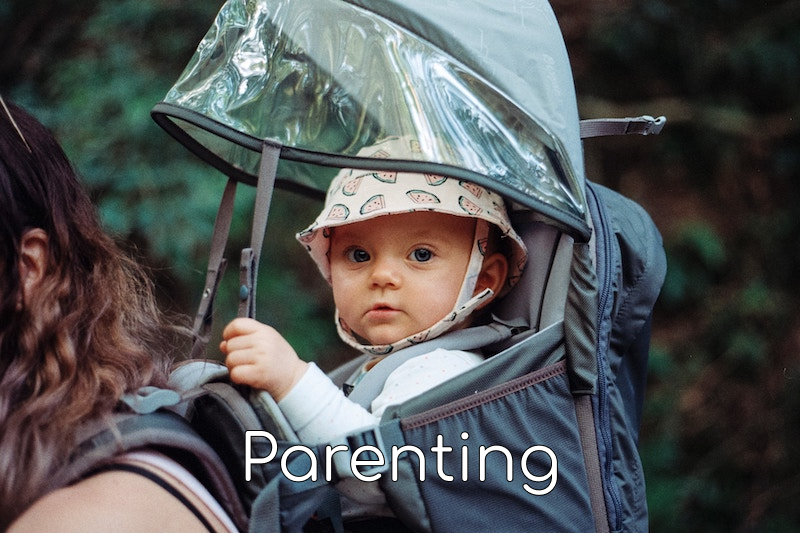 a baby in a backpack carrier with the word parenting at the bottom of the image