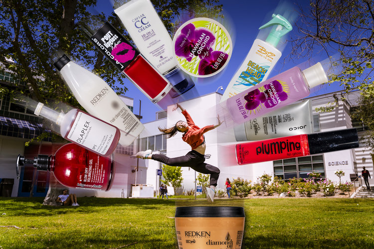 A dancer surrounded by beauty products leaps into the air.