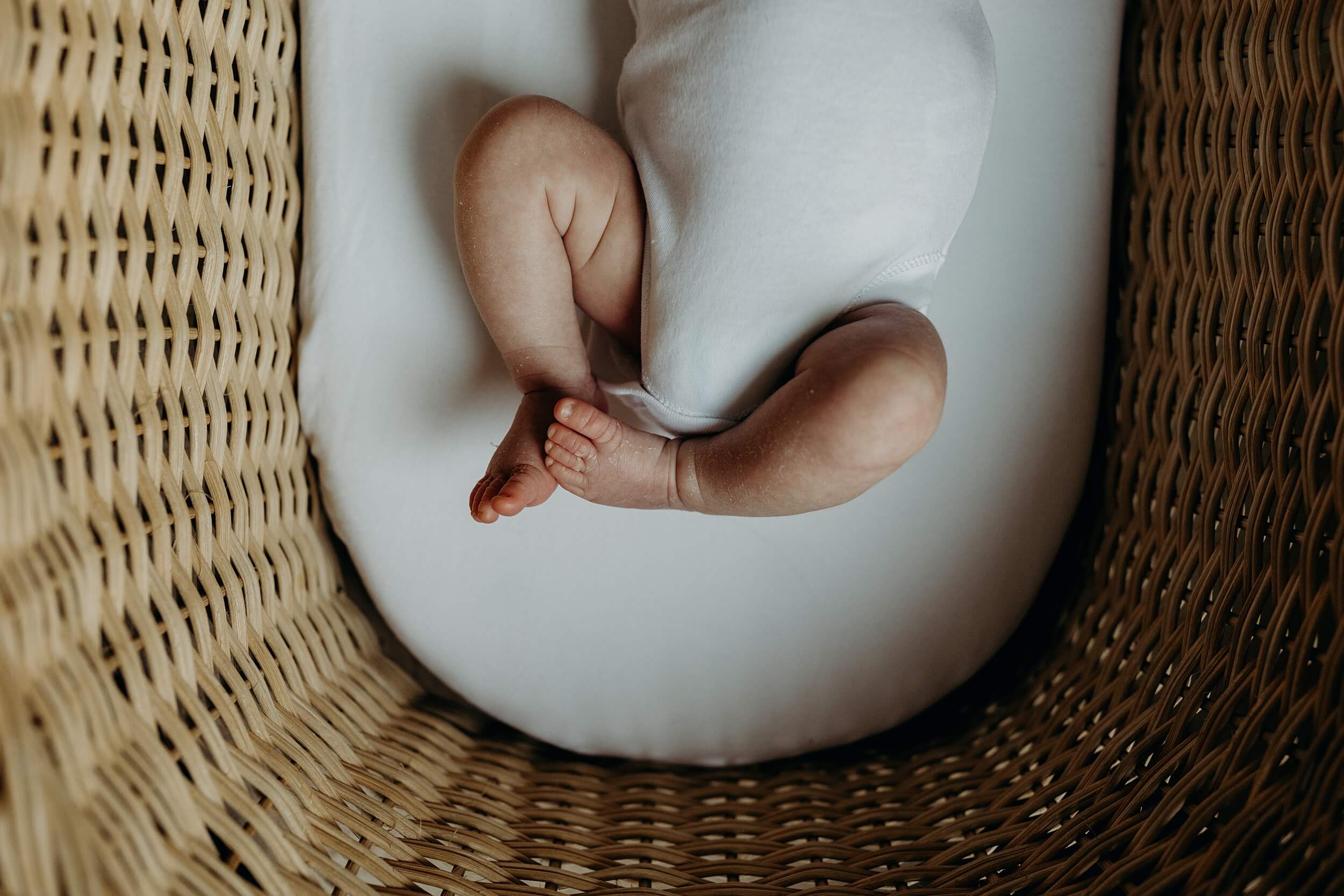 relaxed natural Newborn Photography Glasgow highlighting babies features like toes in the basket
