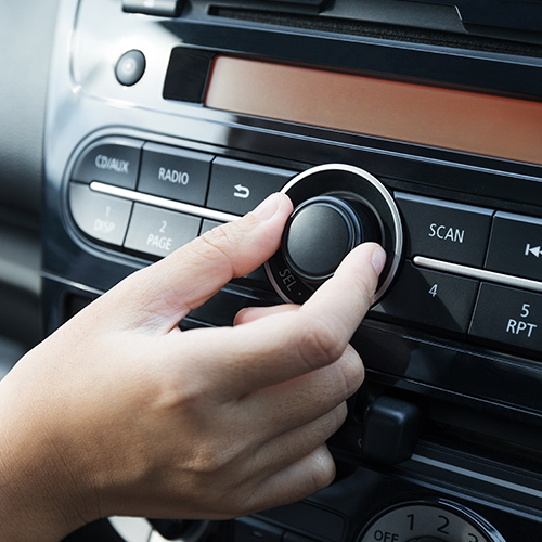 Hand turning up sound in car radio
