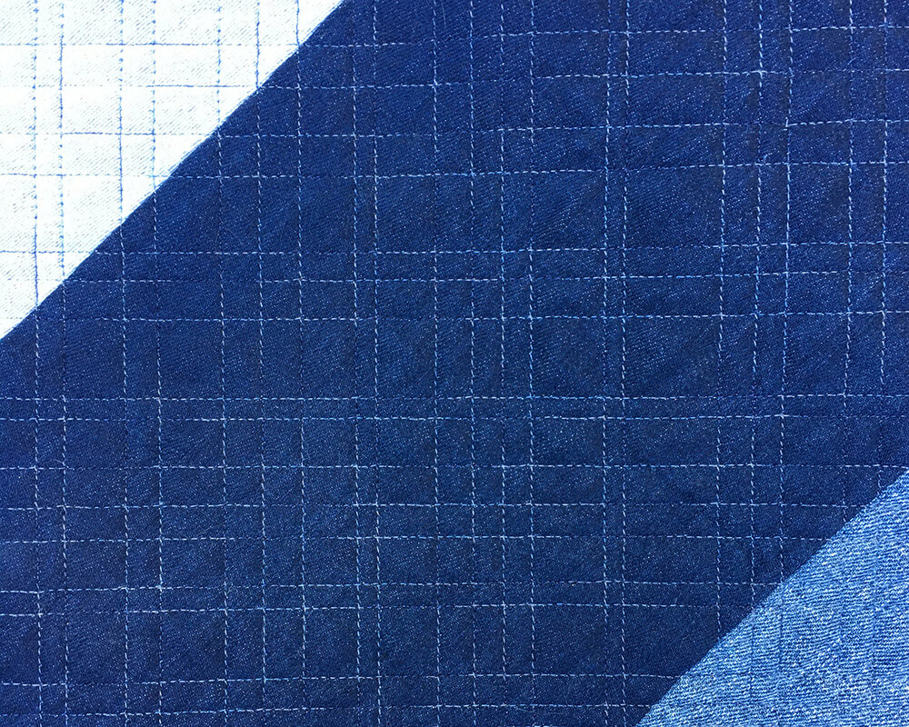 Close up of long arm quilting on a denim quilt
