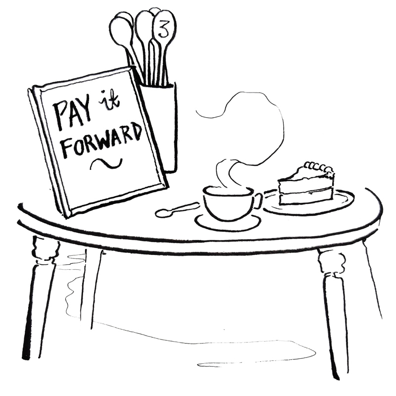 table with coffee and cake and pay it forward board