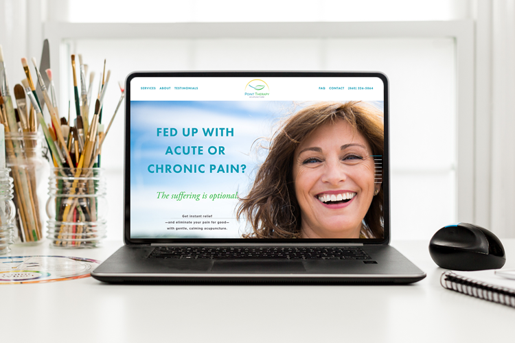 image of a laptop with a woman smiling as the banner image of point therapy's website's home page where the laptop is sitting on a desktop with paint brushes in the background