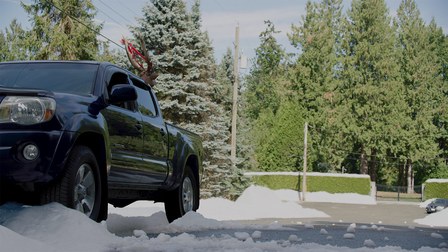 A pickup truck sits on the side of the road in a still from Making Spirits Bright, additional CG snow VFX by Foxtrot X-Ray