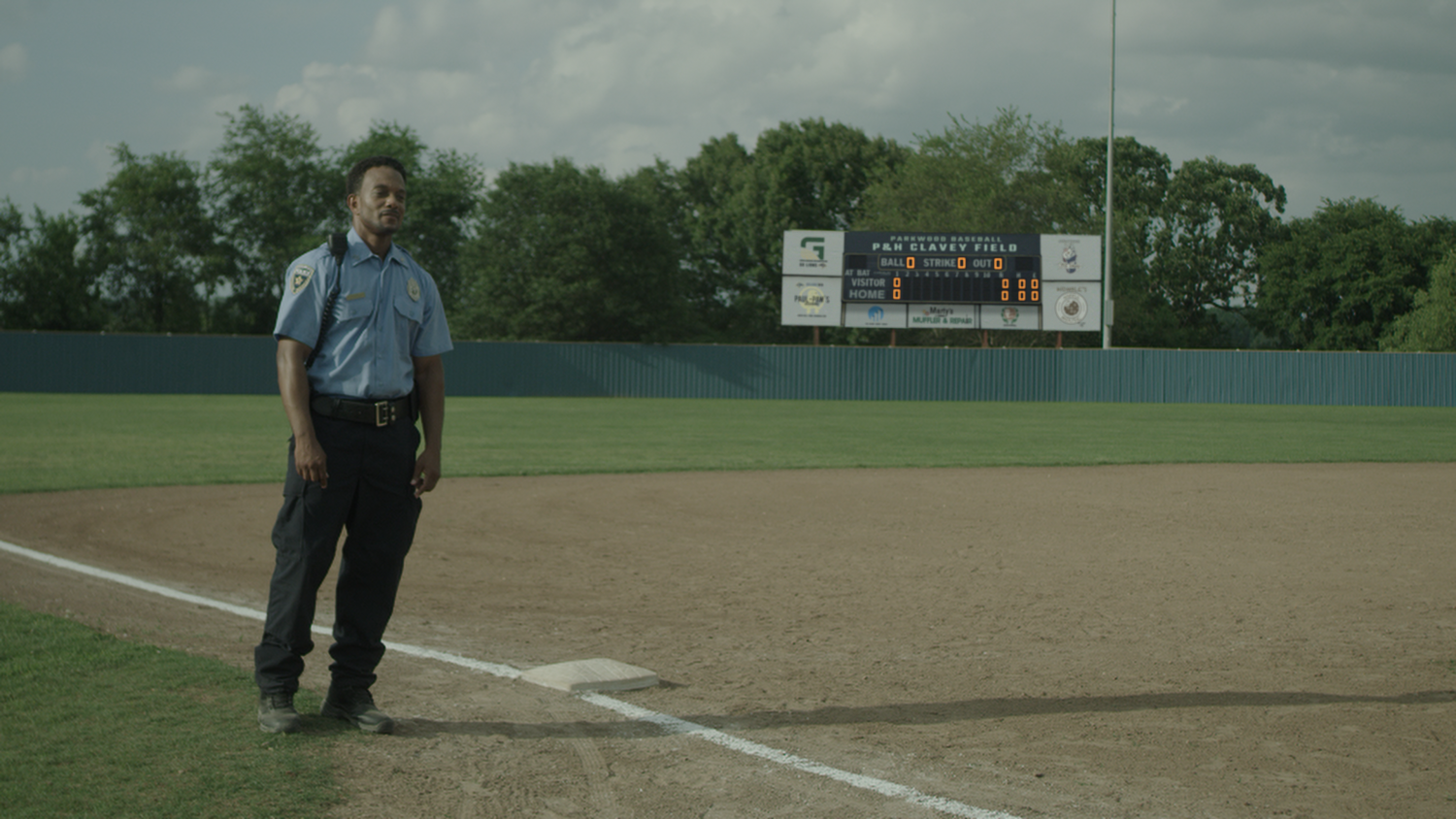 Security guard stands along the 3rd base line