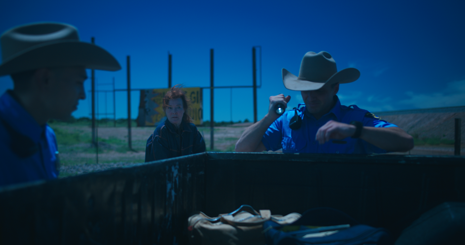 Police search the bed of a pickup truck