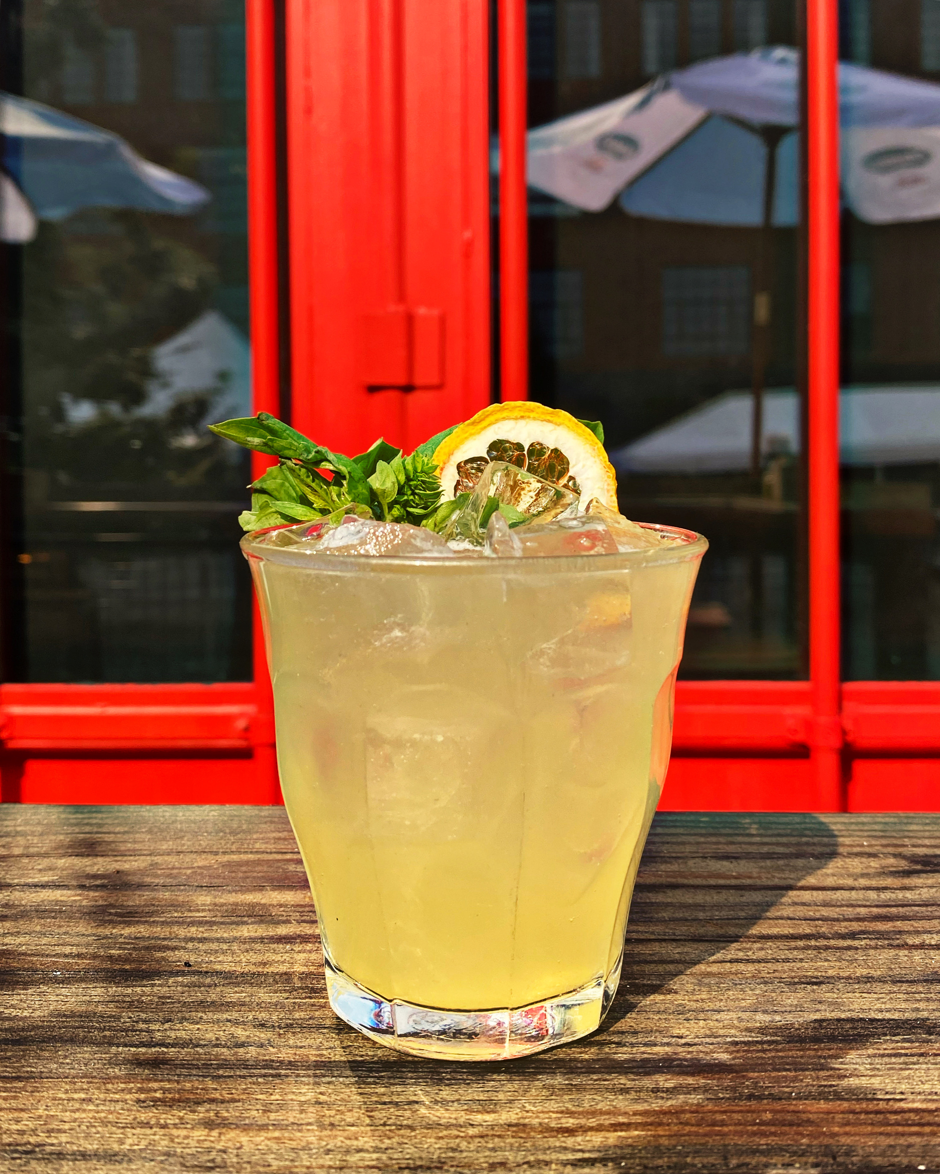 Cocktail with lemon and basil garnish