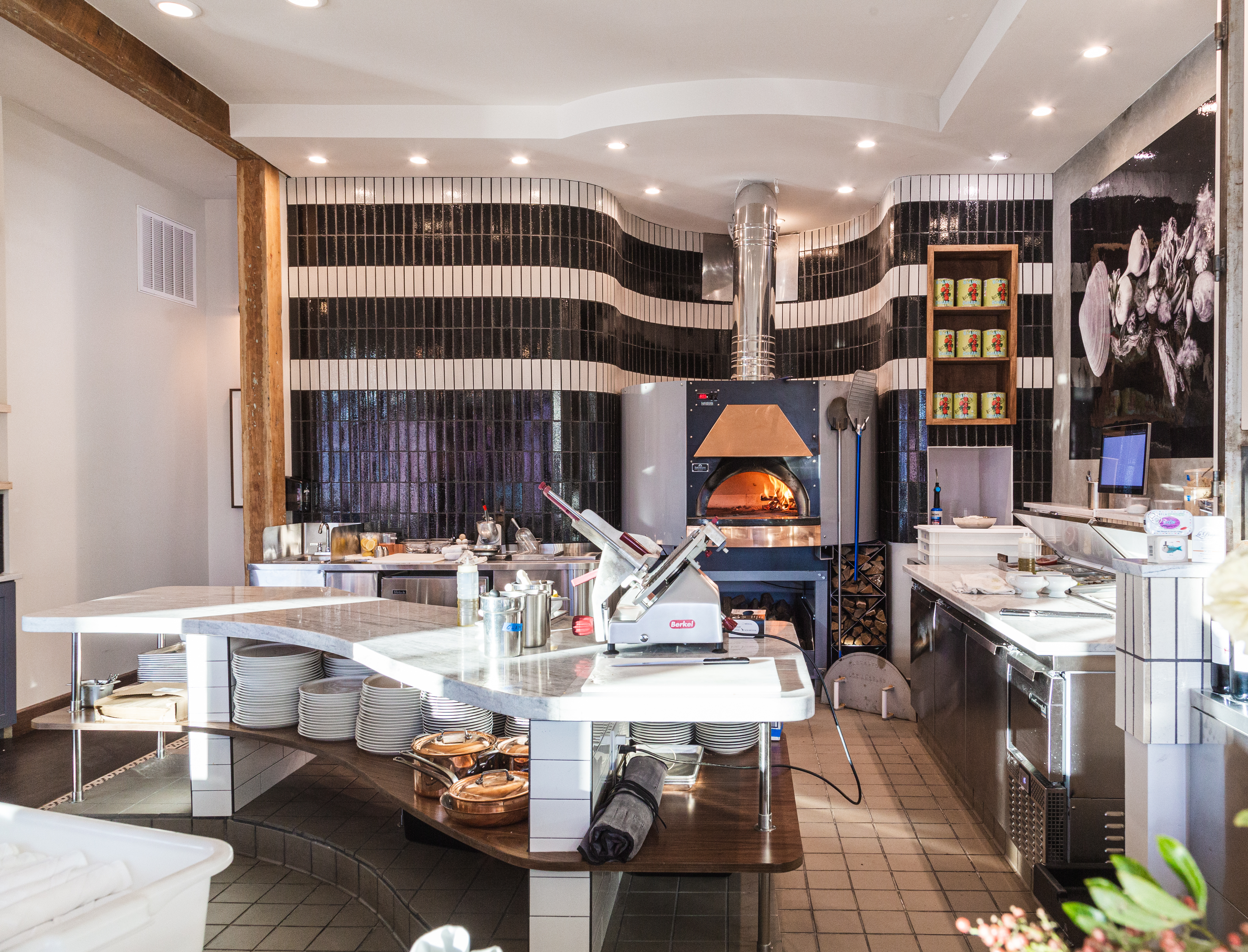 Open concept restaurant kitchen with wood fired pizza oven