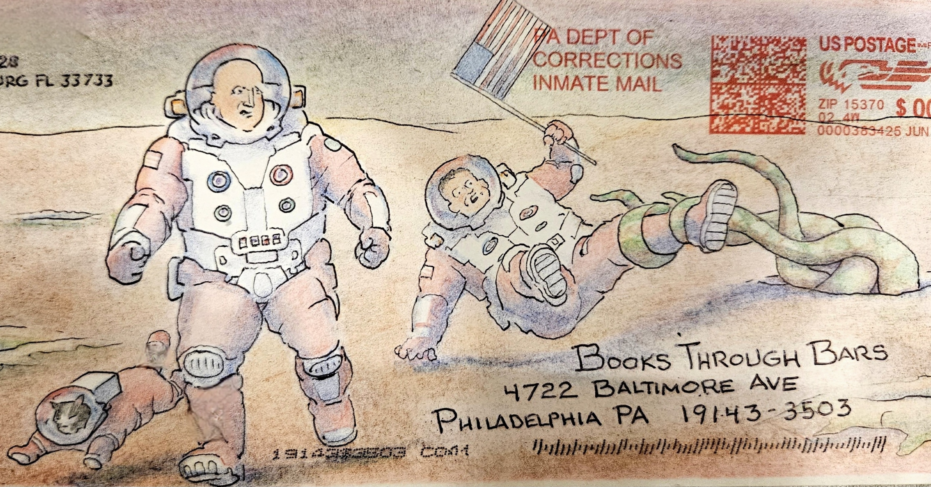 An envelope addressed to Books Through Bars with a drawing of two humans and a cat in space suits. One of the astronauts is holding a United States flag and being pulled by the leg by tentacles emerging from a hole in the ground. The other astronaut looks on in concern.