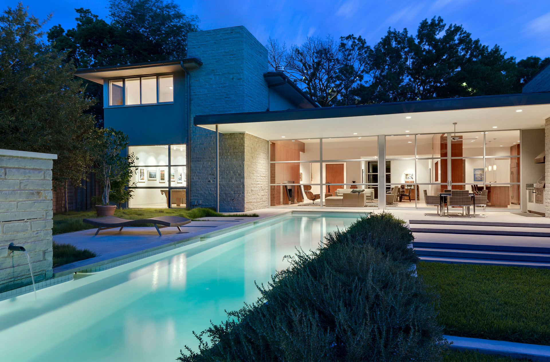 An AIA Home Tour comfortable modern contemporary designed by Bernbaum/Magadini Architects featuring a back yard with pool showing a wall of windows looking into a living room.